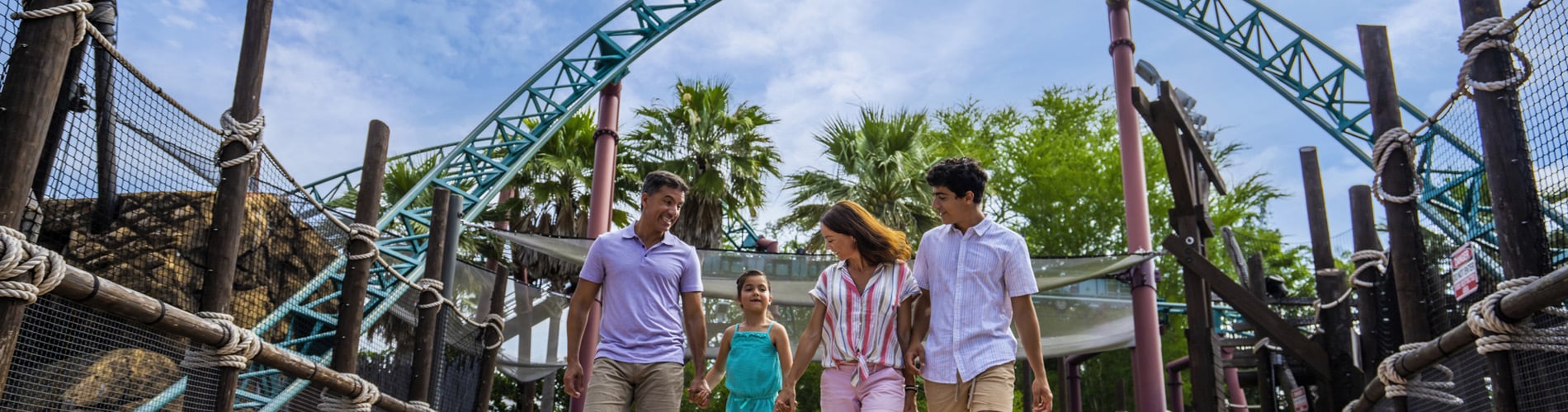 Family walking in frnot of cobra's curse roller coaster