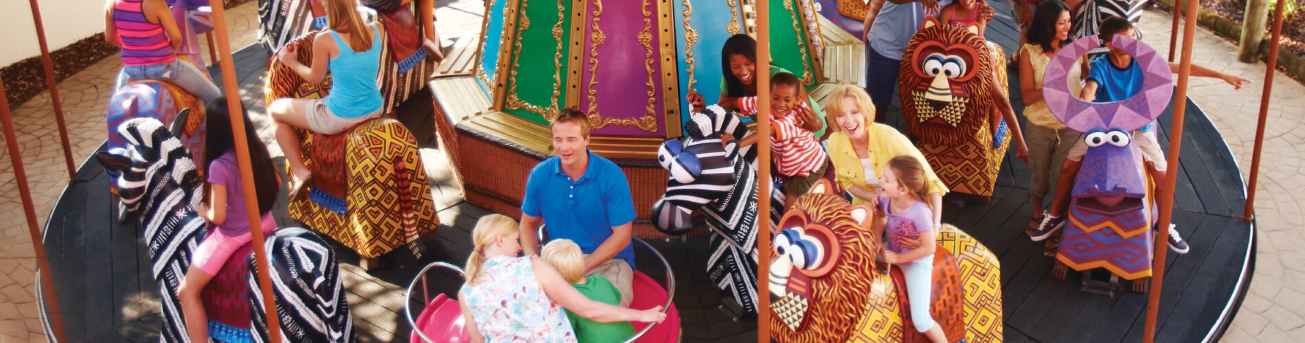 Young kids and parents alike enjoy riding a carousel at Busch Gardens Tampa Bay animal theme park, located in Florida.