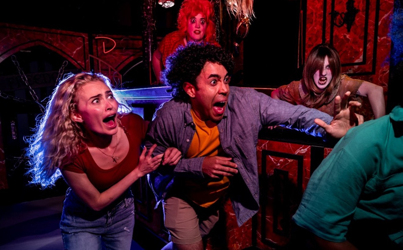 Two people scared inside of Shadows of Wonderland at Busch Gardens Tampa Bay Howl-O-Scream