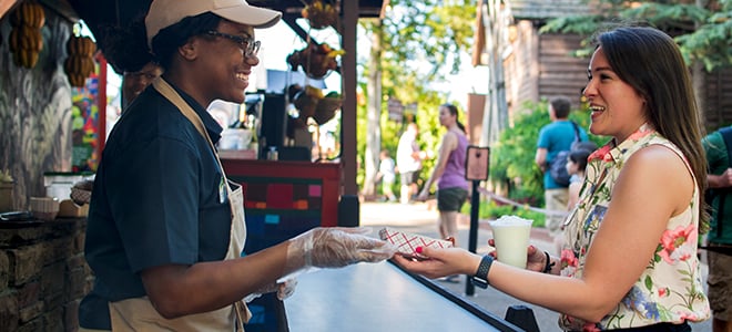 Team Member handing food to woman at Food & Wine Festival